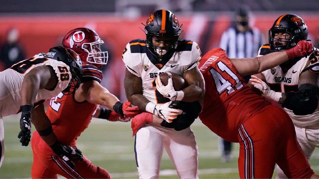 Utah defensive tackle Hauati Pututau (41) tackles Oregon State running back Calvin Tyler Jr., center, during the first half of an NCAA college football game Saturday, Dec. 5, 2020, in Salt Lake City. (AP Photo/Rick Bowmer)