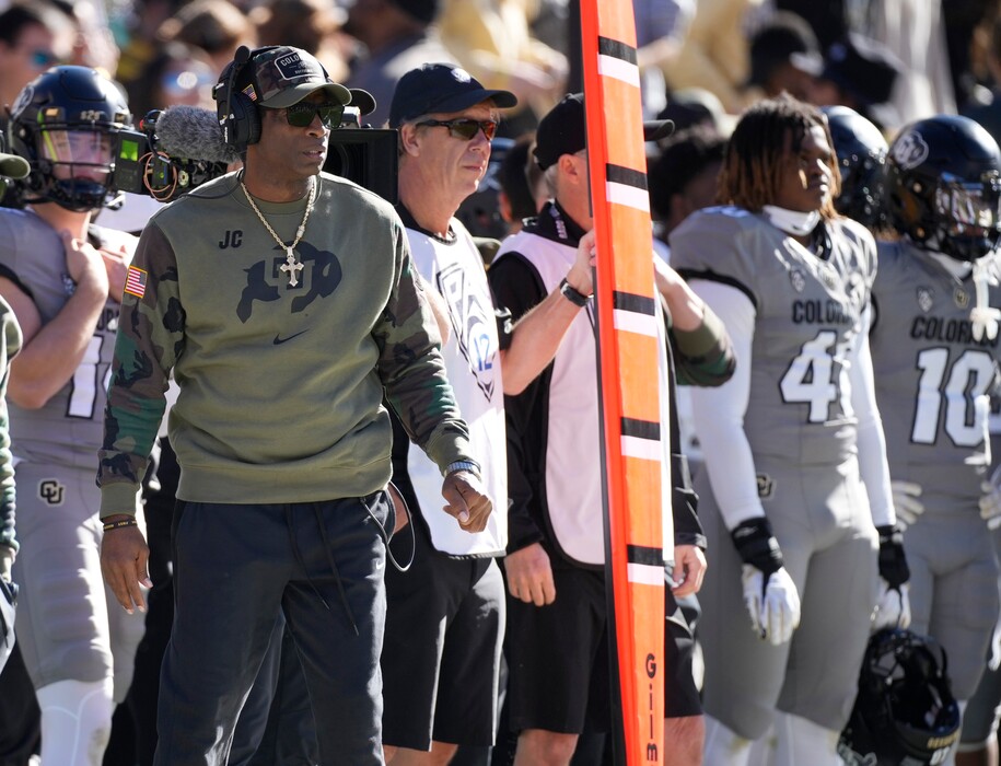 (David Zalubowski | AP) Colorado head coach Deion Sanders, left, looks on in the first half of an NCAA college football game against Arizona on Saturday, Nov. 11, 2023, in Boulder, Colo.