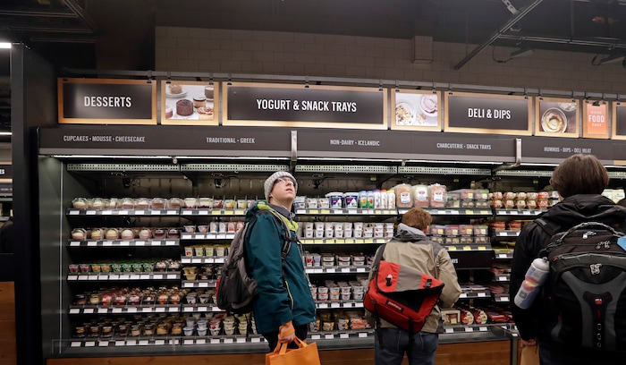 A customer looks overhead in an Amazon Go store, where sensors and cameras are part of a system used to tell what people have purchased and charge their Amazon account, Monday, Jan. 22, 2018, in Seattle. More than a year after it introduced the concept, Amazon opened its artificial intelligence-powered Amazon Go store in downtown Seattle on Monday. (AP Photo/Elaine Thompson)