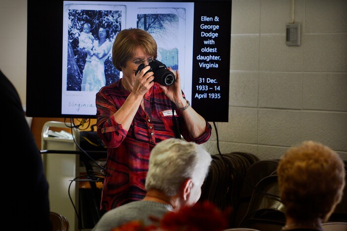 (Scott Sommerdorf | The Salt Lake Tribune) Georgia Dodge Spear makes a new set of family photos as much older ones play on a slide show as Utah and Pennsylvania families gathered for a reunion, Thursday, November 9, 2017 at the Bountiful Tabernacle.