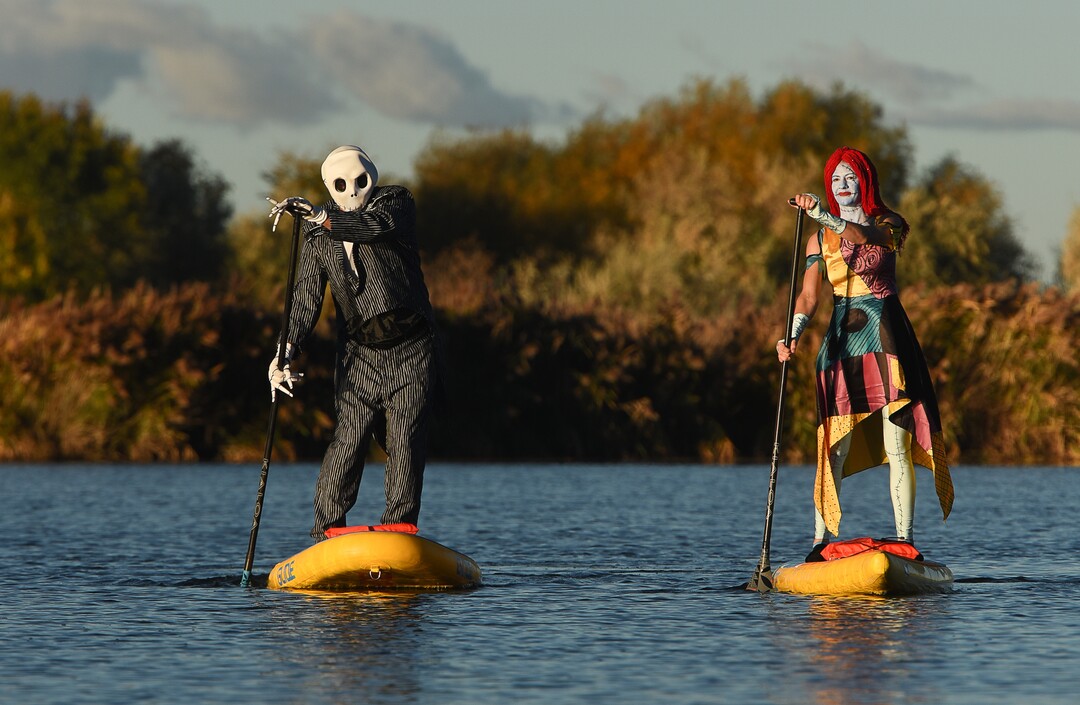 (Francisco Kjolseth  |  The Salt Lake Tribune)  Stand up paddle board enthusiasts Chris Knoles and Roxy Christensen take to the water at Bountiful Pond on Tuesday, Oct. 30, 2018, in what has become a Halloween tradition for the 4th year in a row as they dress up this year as Jack and Sally Skellington from the movie Nightmare Before Christmas. "We paddle year round but actually paddle more in the winter," exclaimed Knoles, who carry the tradition on at Christmas, dressing up in something festive and paddling on the Great Salt Lake where the high salinity usually keeps the water from freezing.
