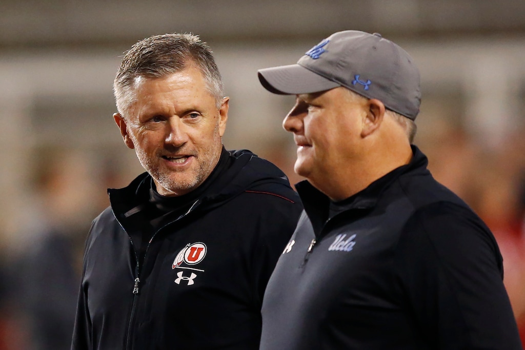 Utah head coach Kyle Whittingham, left, and UCLA head coach Chip Kelly, right, speak before an NCAA college football game Saturday, Nov. 16, 2019, in Salt Lake City. (AP Photo/Rick Bowmer)