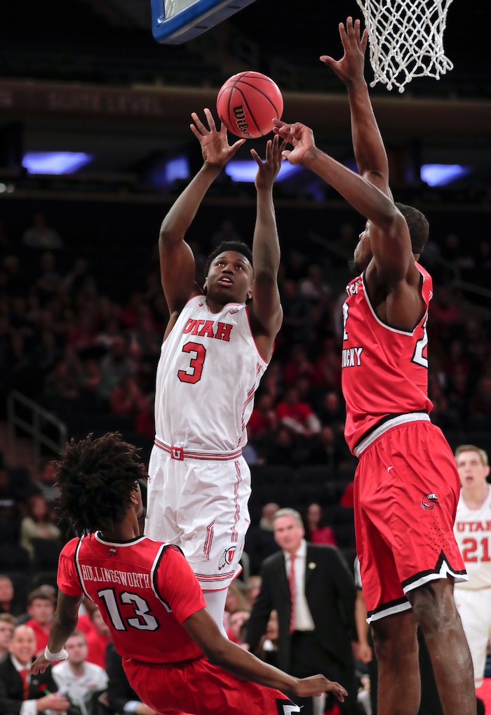 Utah forward Donnie Tillman (3) shoots as Western Kentucky guard Taveion Hollingsworth (13) and forward Dwight Coleby (22) defend during the first half of an NCAA college basketball game in the semifinals of the NIT, Tuesday, March 27, 2018, in New York. (AP Photo/Julie Jacobson)