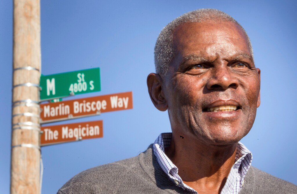 FILE - In this Oct. 22, 2014, file photo, Marlin Briscoe stands in front of a street that was renamed for him in Omaha, Neb. The Pro Football Hall of Fame calls the Omaha, Neb. native the first black quarterback in the modern era of pro football. He opened the door for many, including Carolina's Cam Newton and Seattle's Russell Wilson, who both pay homage to him. (Kent Sievers/Omaha World-Herald via AP, File)