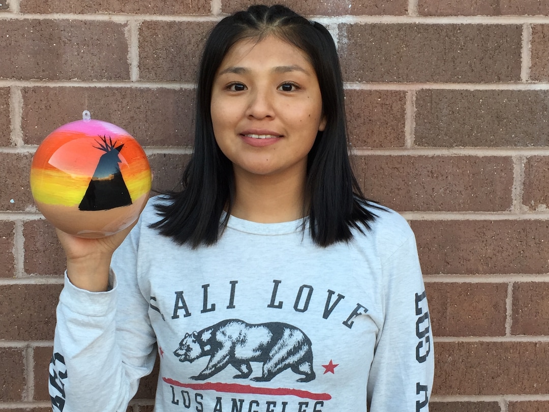 (Photo courtesy of Georgiana Simpson) A student at Whitehorse High School holds an ornament she painted.