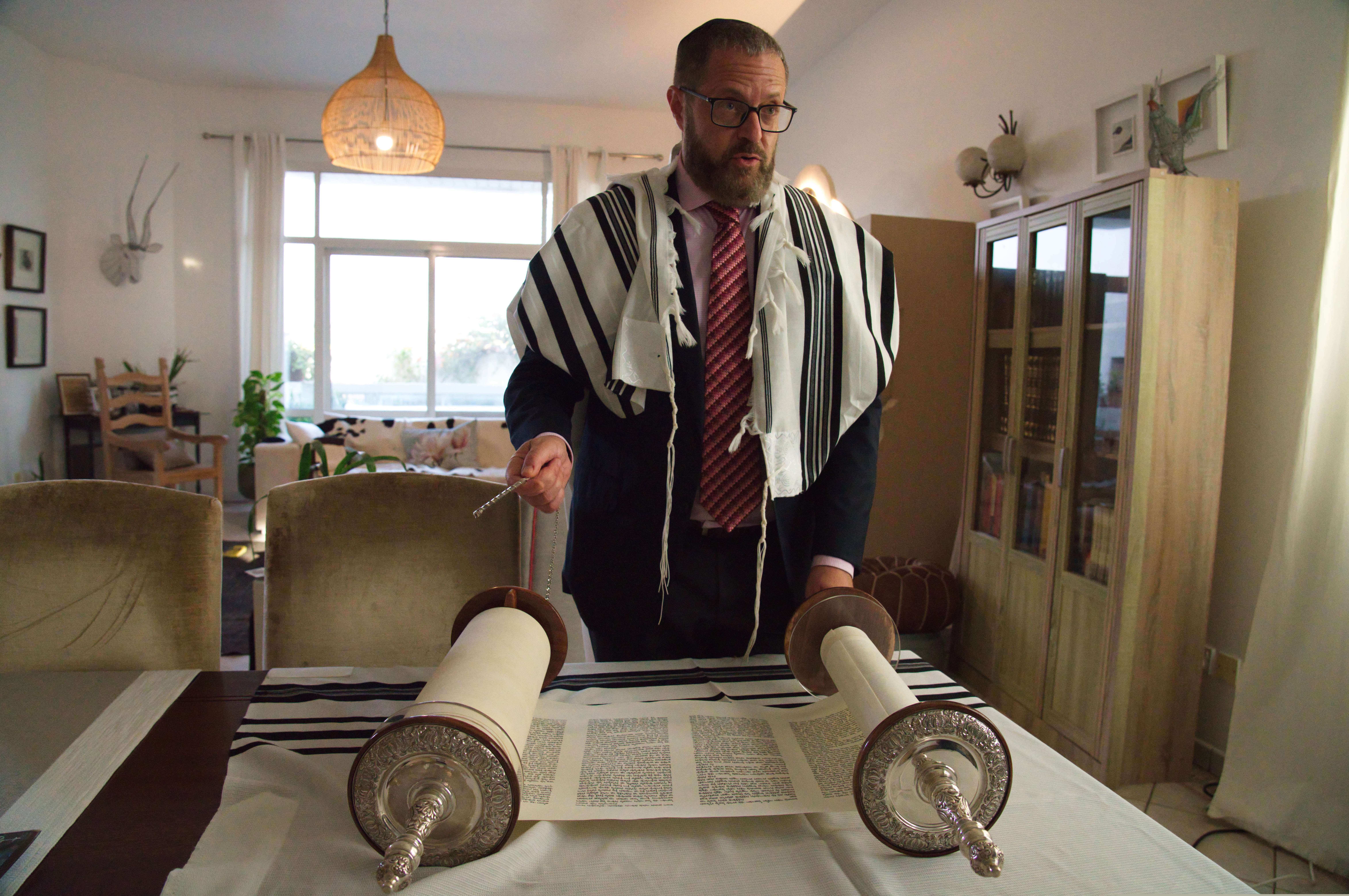 (Jon Gambrell | AP) Alex Peterfreund, a co-founder of Dubai's Jewish community and its cantor, prepares to read from the Torah in Dubai, United Arab Emirates, Sunday, Aug. 16, 2020. Telephone service between the United Arab Emirates and Israel began working Sunday as the two countries opened diplomatic ties, part of a deal brokered by the U.S. that required Israel to halt its contentious plan to annex West Bank land sought by the Palestinians for a future state.