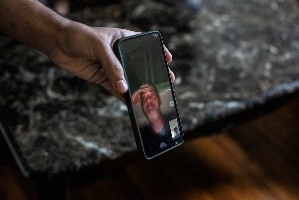 (Bryan Anselm | The New York Times) Ahmed Abufares holds his phone during a video call with his father, Fares, who is currently in Gaza, in his home in Clifton, N.J., on Oct. 12, 2023. As bombs fall and phone batteries run low, Palestinian American families caught in the Israel-Hamas war wonder whether the U.S. government will help them escape.