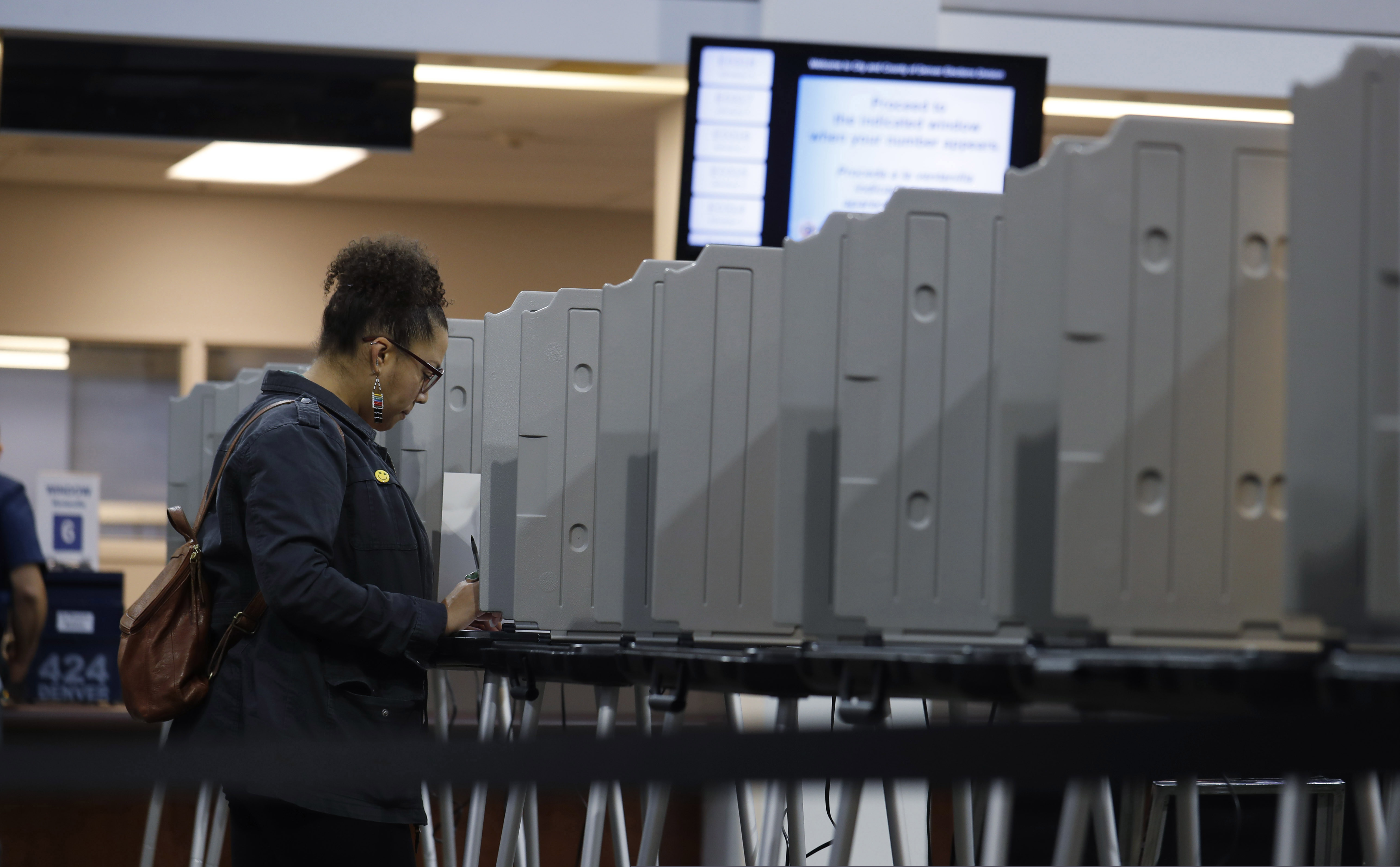 (David Zalubowski | AP file photo) In this Tuesday, Nov. 5, 2020, file photo, a lone voter fills out a ballot in the lobby of the Denver Elections Division in downtown Denver. Tuesday’s presidential primaries across 14 states mark the first major security test since the 2018 midterm elections.