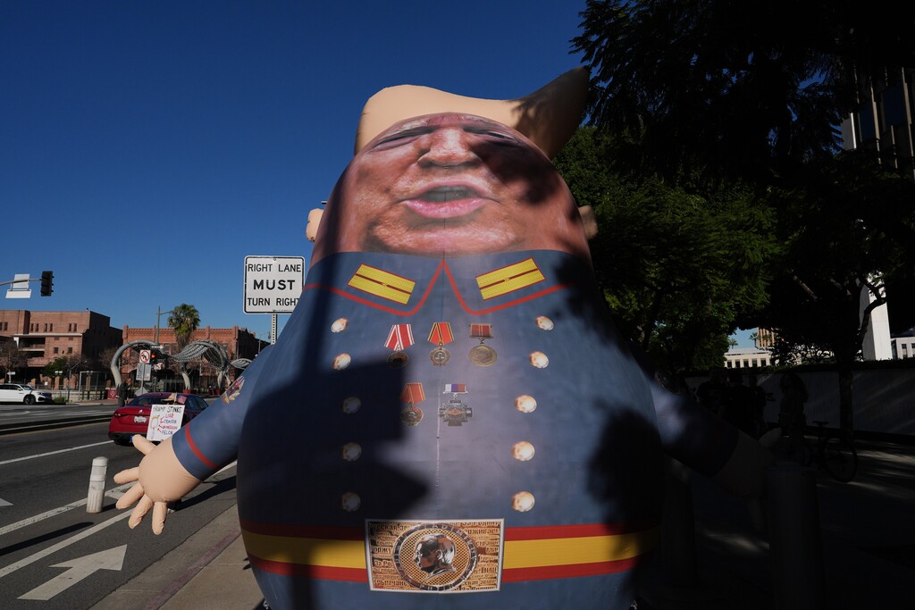 A balloon in the shape of President Donald Trump is placed along a sidewalk during a protest to denounce the Trump administration's immigration enforcement polices Friday, Jan. 16, 2026, in Los Angeles. (AP Photo/Jae C. Hong)