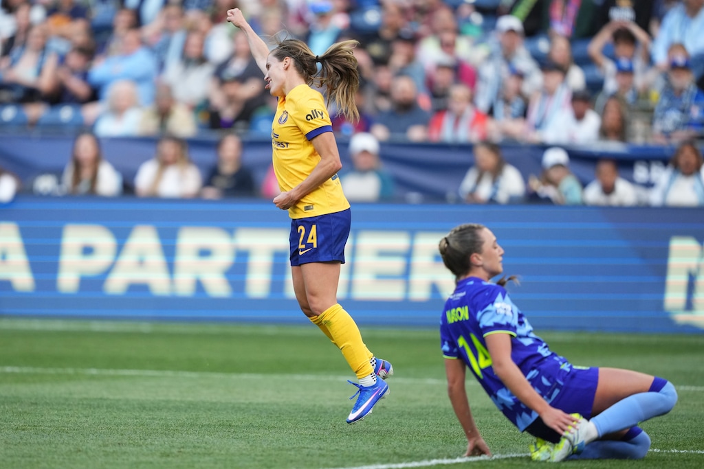 Utah Royals forward Cloé Lacasse (24) celebrates a goal as Seattle Reign FC defender Emily Mason looks away during the first half of an NWSL soccer match, Sunday, April 26, 2026, in Seattle. (AP Photo/Lindsey Wasson)