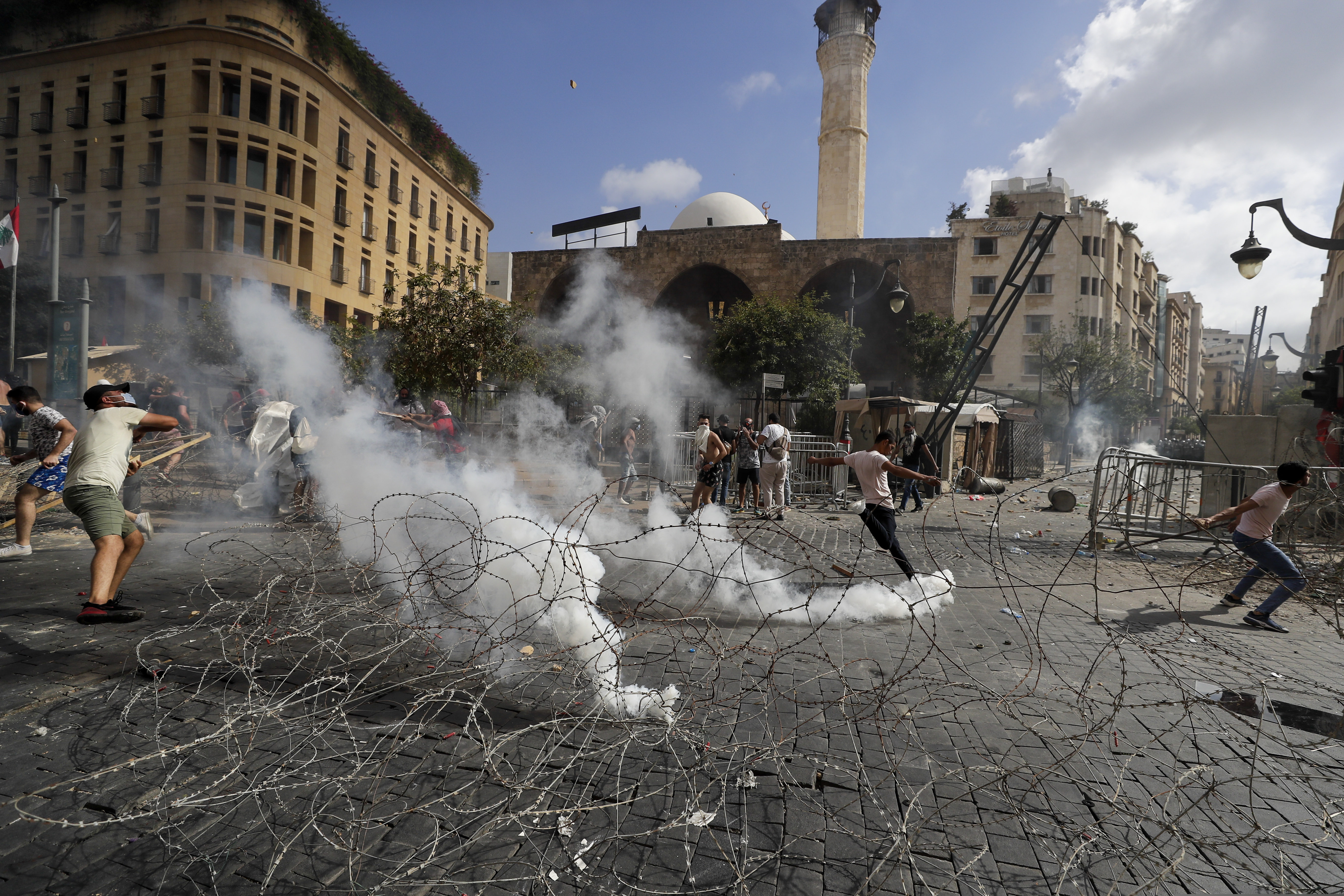 (Hassan Ammar | AP) People clash with police during a protest against the political elites and the government after this week's deadly explosion at Beirut port which devastated large parts of the capital and killed more than 150 people, in Beirut, Lebanon, Saturday, Aug. 8, 2020.