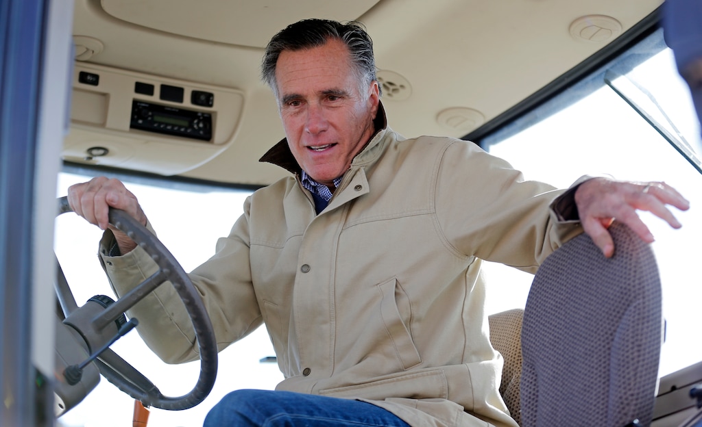 Former Republican presidential candidate Mitt Romney holds the wheel of a tractor during a tour of Gibson's Green Acres Dairy Friday, Feb. 16, 2018, in Ogden, Utah. The 2012 Republican presidential candidate plans to bid for the seat being vacated by retiring seven-term Utah Sen. Orrin Hatch. (AP Photo/Rick Bowmer)