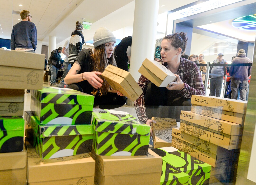 Leah Hogsten  |  The Salt Lake Tribune  l-r Kuru footwear employees Kasey Murphy and Ashley Owen hand out new shoes to homeless and low-income families at the Utah Jazz and the Larry H. Miller Group sponsored annual “We Care – We Share” Thanksgiving Meal and benefit, Monday, Nov 19, 2018.