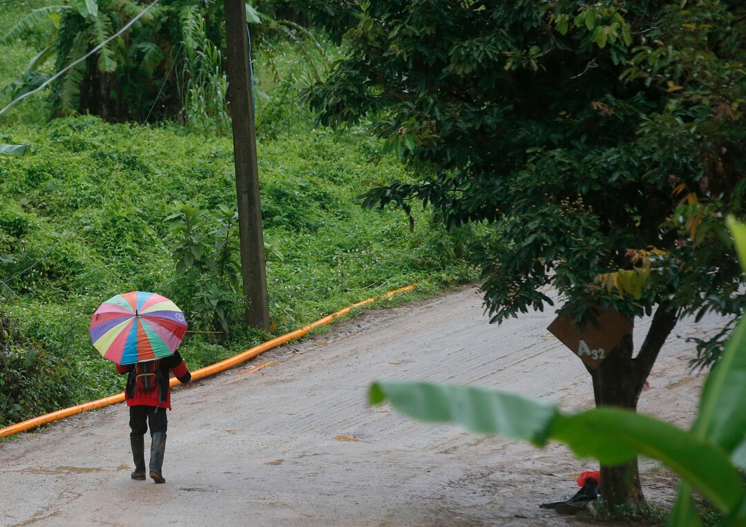 A rescuer moves to the entrance to a cave complex where five still were trapped in Mae Sai, Chiang Rai province, northern Thailand Tuesday, July 10, 2018. The eight boys were rescued from the flooded cave. (AP Photo/Sakchai Lalit)
