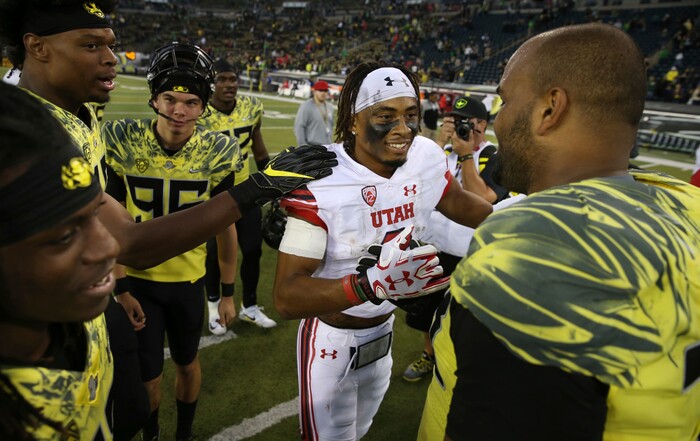 Utah's Darren Carrington II, center, meets with Oregon players after their NCAA college football game Saturday, Oct. 28, 2017, in Eugene, Ore. Carrington II was dismissed from Oregon before the 2017 season and transferred to Utah. (AP Photo/Chris Pietsch)