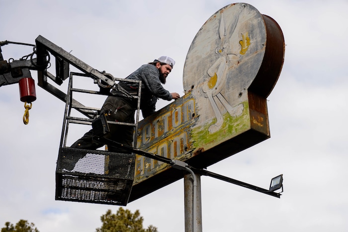 (Trent Nelson  |  The Salt Lake Tribune) Spencer Gillies works to remove the iconic sign at the Cotton Bottom Inn in Holladay on Thursday, Jan. 9, 2020. The sign is being restored by Brimley Neon, which specializes in vintage sign repair.