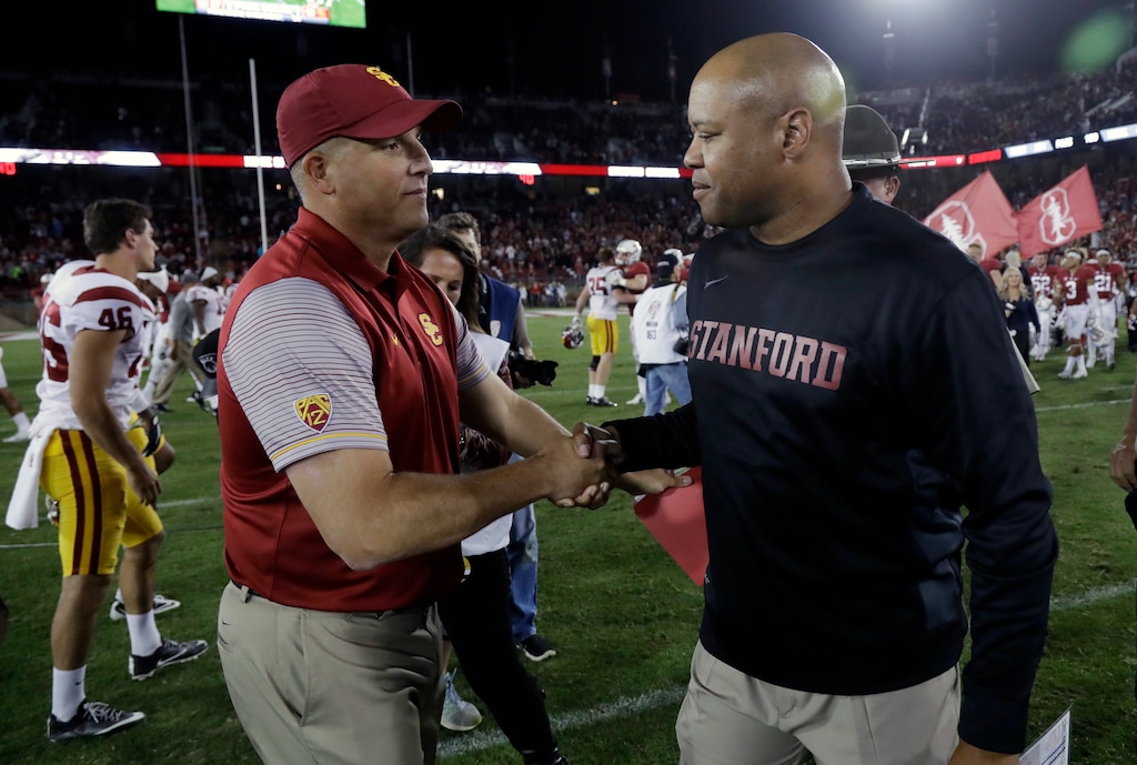 USC coach Clay Helton, left, shakes hands with Stanford coach David Shaw after their game last season. (AP Photo/Marcio Jose Sanchez)