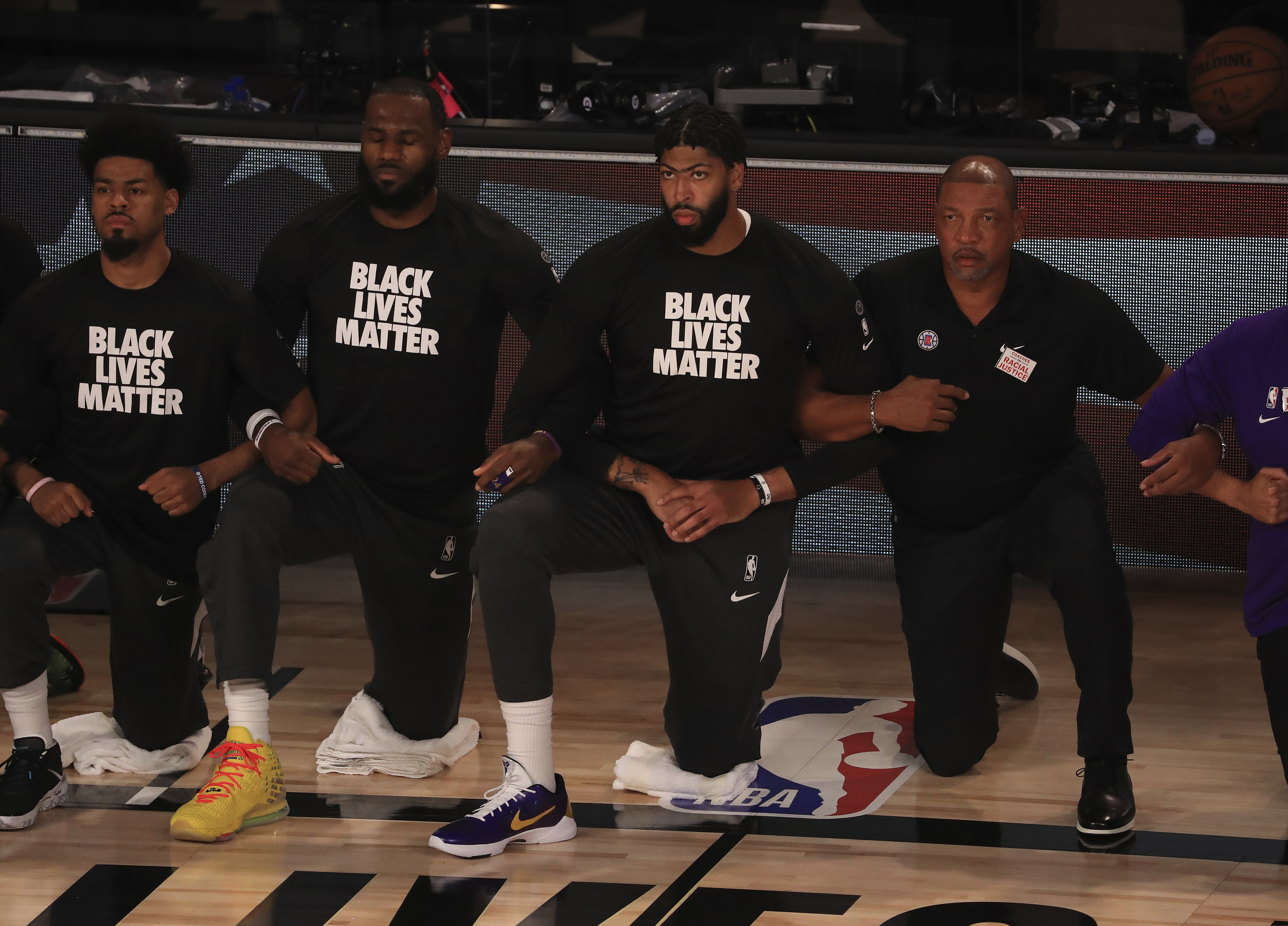 Los Angeles Lakers' LeBron James, second from left, wears a Black Lives Matter shirt and kneels with teammates during the national anthem prior to an NBA basketball game against the Los Angeles Clippers, Thursday, July 30, 2020, in Lake Buena Vista, Fla. (Mike Ehrmann/Pool Photo via AP)