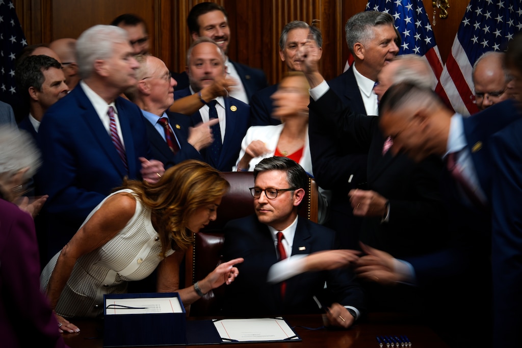 (Julia Demaree Nikhinson | AP) Republican members of Congress reach to shake hands with Speaker of the House Mike Johnson, R-La., center bottom, after Johnson signed President Donald Trump's signature bill of tax breaks and spending cuts, Thursday, July 3, 2025, at the Capitol in Washington.