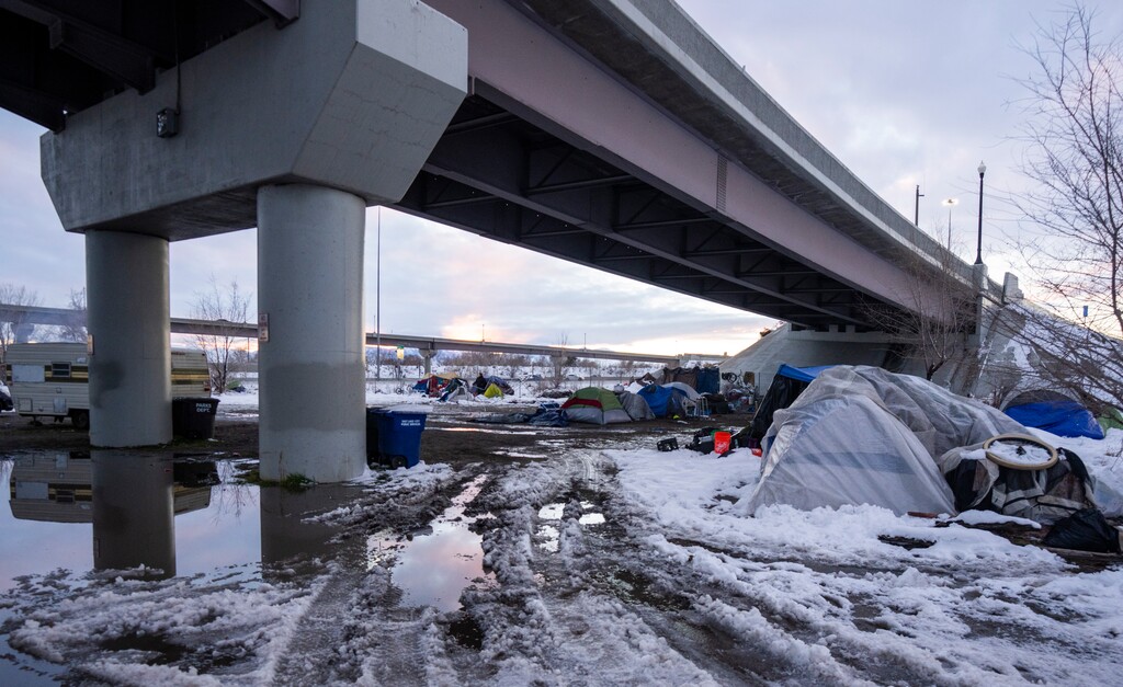 (Rick Egan |  Tribune file photo) People experiencing homelessness, search for areas under bridges for shelter, after being pushed from location to location, on Friday, December 17, 2021.