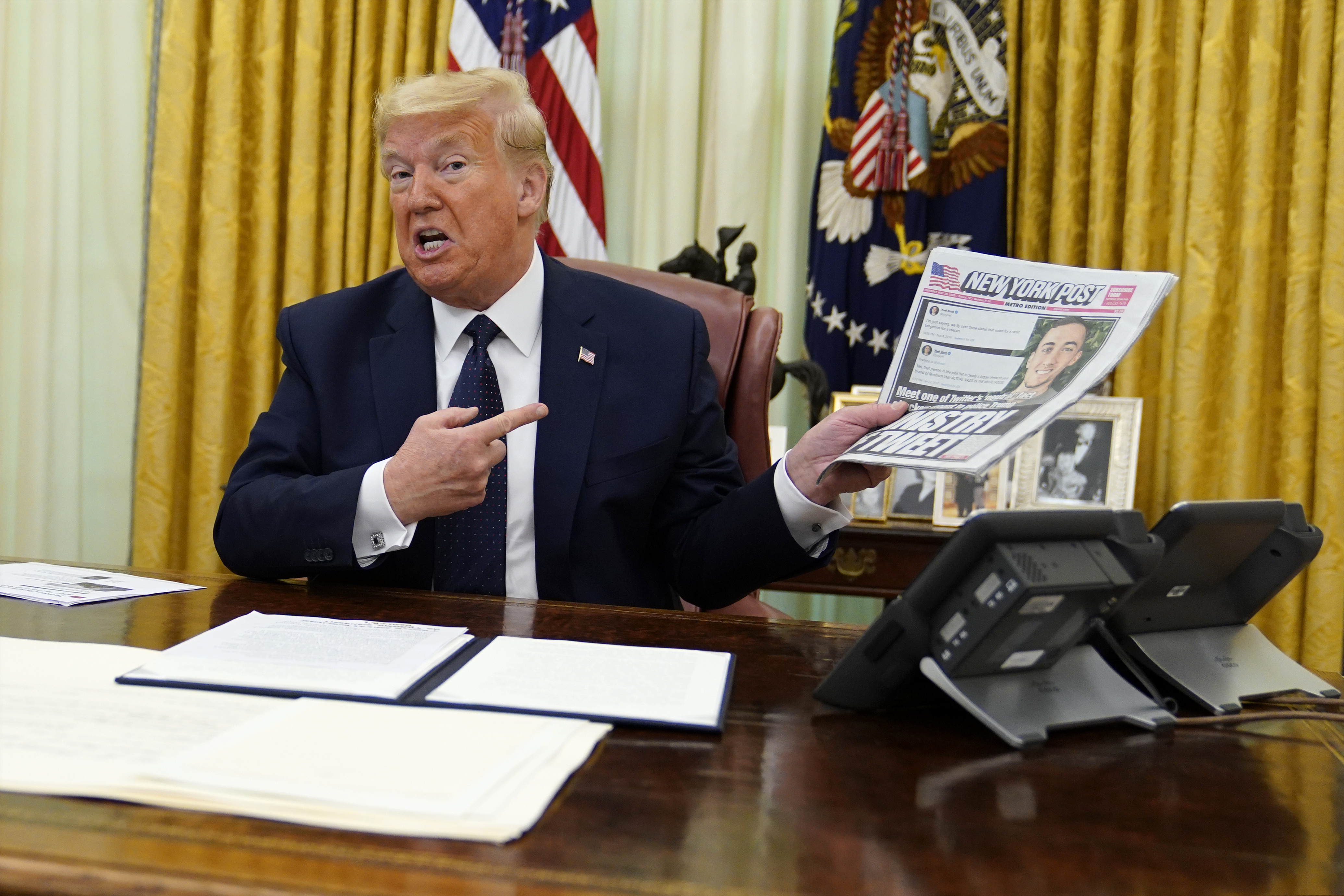 (Evan Vucci | AP) President Donald Trump holds up a copy of the New York Post as speaks before signing an executive order aimed at curbing protections for social media giants, in the Oval Office of the White House, Thursday, May 28, 2020, in Washington.