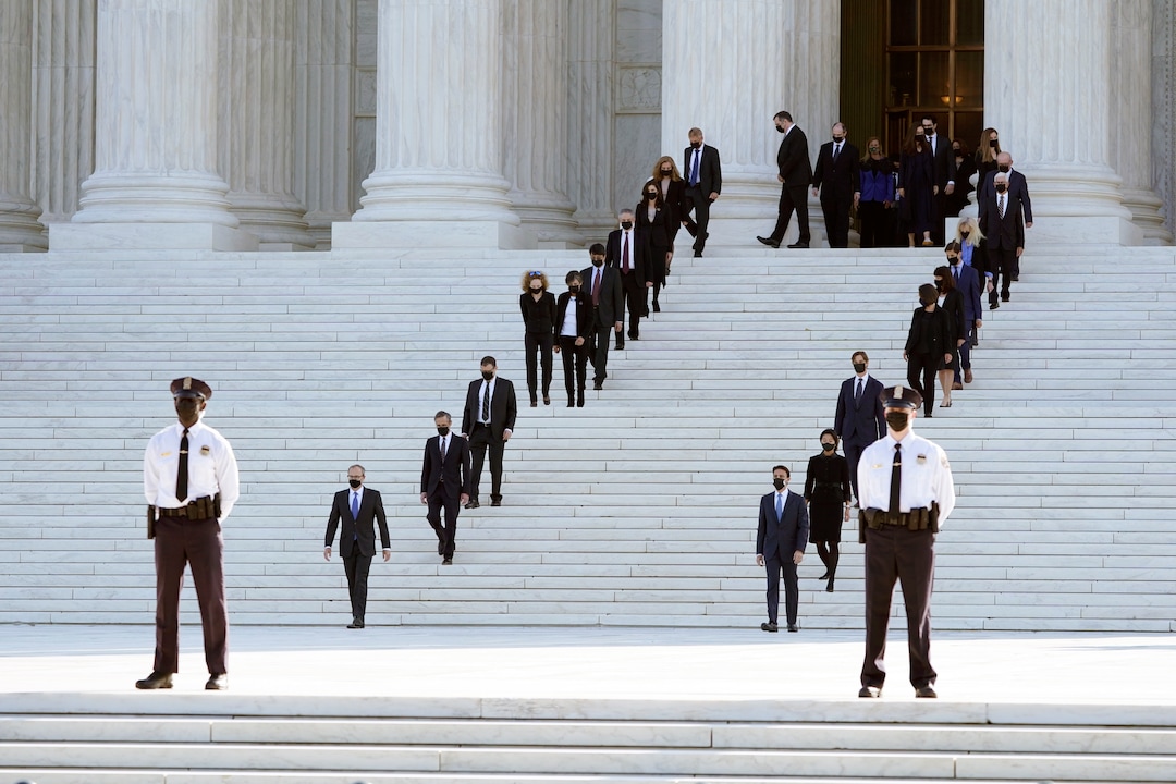 Former law clerks walk out and stand for the casket of Justice Ruth Bader Ginsburg to arrive at the Supreme Court in Washington, Wednesday, Sept. 23, 2020. Ginsburg, 87, died of cancer on Sept. 18. (AP Photo/Patrick Semansky)