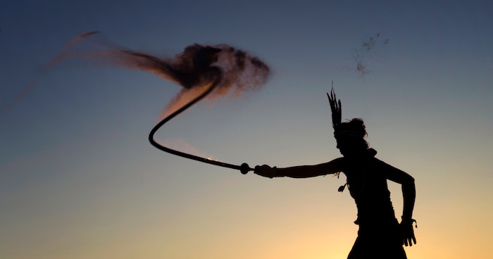 (Rick Egan  |  The Salt Lake Tribune)Melissa the Blazing Whiptress, of Salt Lake City, cracks a burning whip, at sunrise, during Burning Man, Saturday, September 2, 2017.