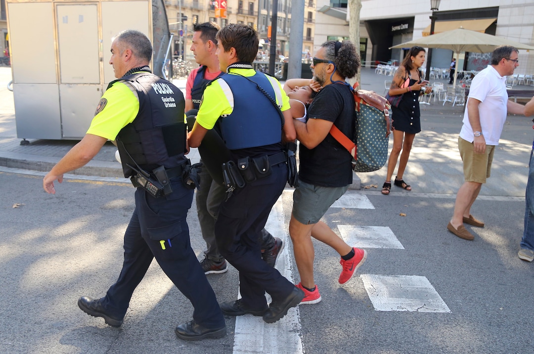 An injured person is carried in Barcelona, Spain, Thursday, Aug. 17, 2017 after a white van jumped the sidewalk in the historic Las Ramblas district, crashing into a summer crowd of residents and tourists and injuring several people, police said. (AP Photo/Oriol Duran)