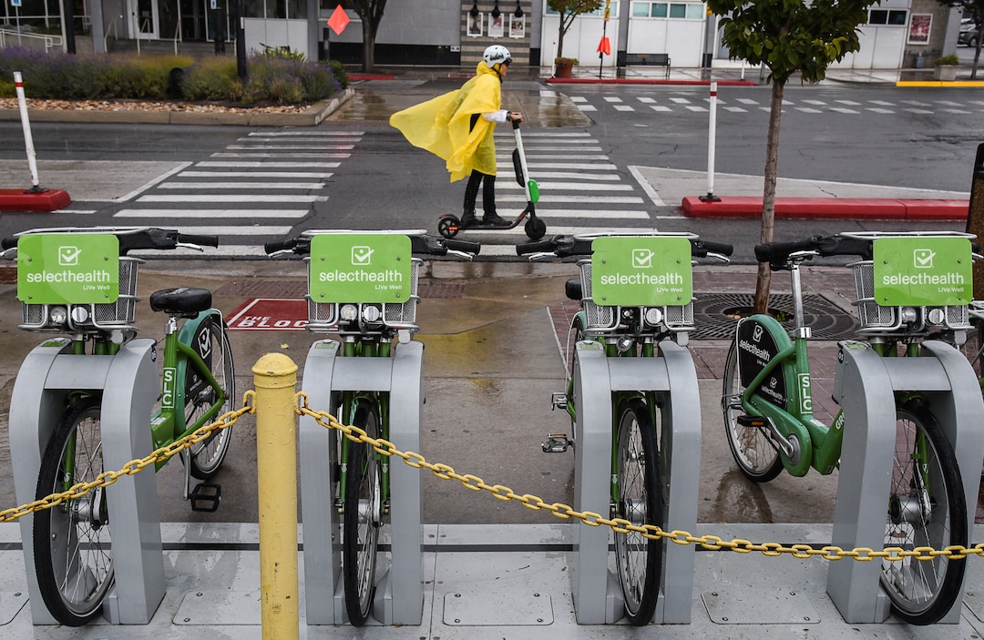 (Francisco Kjolseth  |  The Salt Lake Tribune)  An electric scooter rider braves the rain in downtown Salt Lake City on Tuesday, Oct. 2, 2108. GreenBike was on track to have their best year yet but then Lime and Bird scooters derailed their momentum.