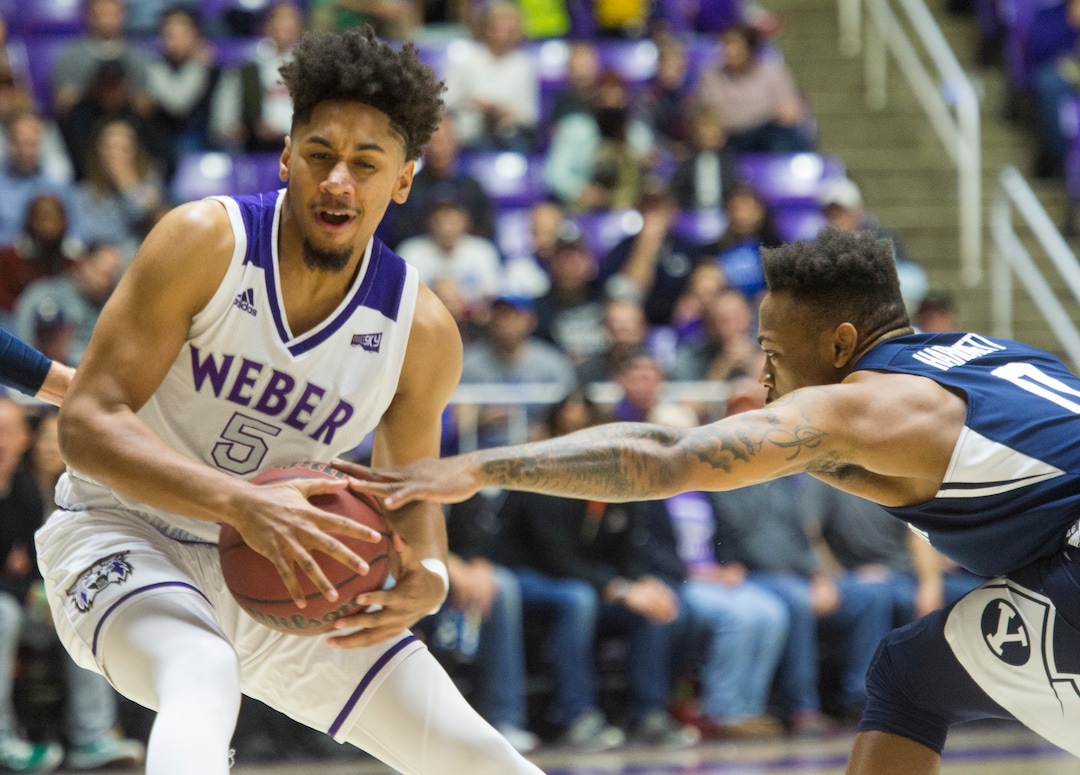 (Rick Egan  |  The Salt Lake Tribune)      Brigham Young Cougars guard Jahshire Hardnett (0) gets a hand on the ball, as Weber State Wildcats guard Cody John (5) moves toward the basket, in basketball action between Brigham Young Cougars and Weber State Wildcats, at the Dee Event Center in Ogden, Saturday, Dec. 1, 2018.