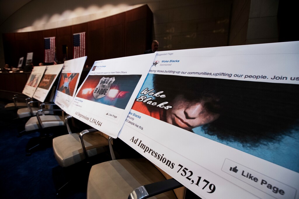 FILE- In this Nov. 1, 2017, file photo, Facebook ads linked to a Russian effort to disrupt the American political process are displayed as Google's Senior Vice President and General Counsel Kent Walker, Facebook's General Counsel Colin Stretch, and Twitter's Acting General Counsel Sean Edgett, testify during a House Intelligence Committee hearing on Capitol Hill in Washington. Facebook says it will require political advertisers in the U.S. to label “issue ads” that disclose who paid for them, part of its ongoing efforts to prevent elections-related misuse of its platform. Such ads played prominently in Russia’s efforts to interfere in the 2016 U.S. elections. (AP Photo/Manuel Balce Ceneta, File)