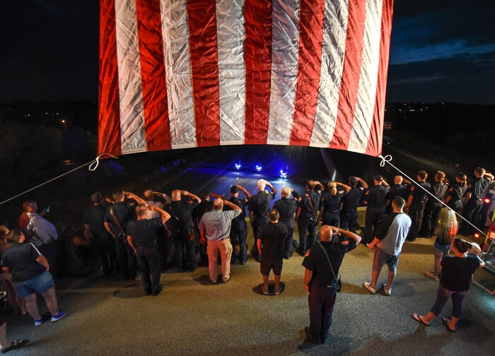 (Francisco Kjolseth  |  The Salt Lake Tribune)  The body of Utah firefighter Matt Burchett, 42, who died fighting a wildfire in California is honored by a firefighter detail along Murray Parkway as his body is returned home, traveling along I-215 after being flown in to the Utah Air National Guard in Salt Lake City on Wed. Aug. 15, 2018. The remains of the Draper battalion chief were transported to Jenkins-Soffe Mortuary in South Jordan.