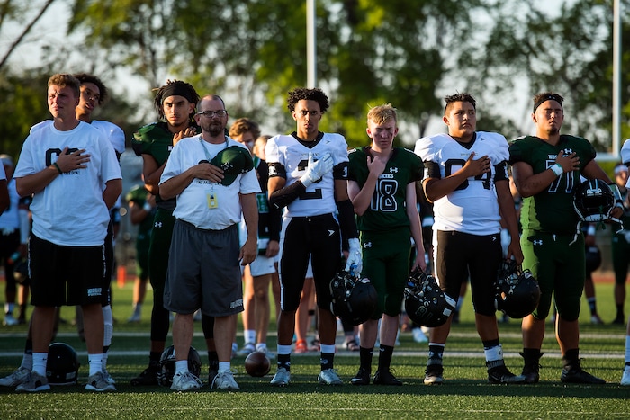(Chris Detrick  |  The Salt Lake Tribune)    Members of the Hillcrest and Highland football teams listen to the National Anthem before the game at Hillcrest High School Friday, September 1, 2017. Cazzie Brown passed away Sunday night after spending four days in the hospital. According to a family representative, Brown was brought to the emergency room Wednesday for complications with his thyroid. The doctors found that he had contracted meningitis, and later received a preliminary positive after being tested for West Nile virus. 