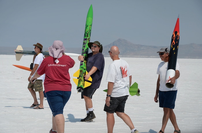 (Scott Sommerdorf   |  The Salt Lake Tribune)   Travis Tabbal, center, and his wife, Kelly, second from left, walk their rocket back after posing in a group photo during "HellFire" — the event sponsored by the Utah Rocket Club on Saturday, Aug. 5, 2017.
