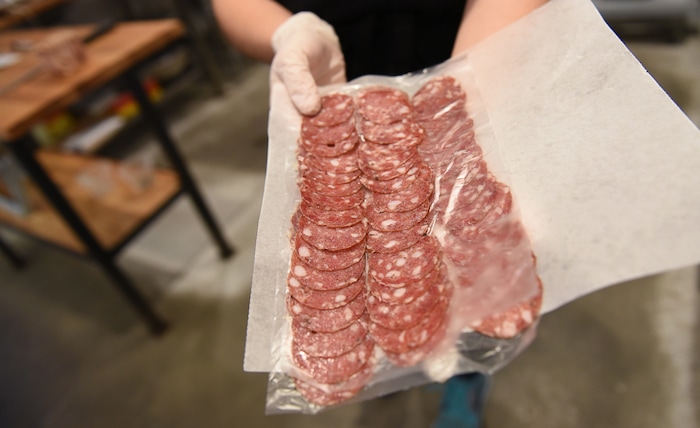 (Francisco Kjolseth  |  The Salt Lake Tribune)  Tressa Marre prepares salami slices for a customer at Beltex Meats in Salt Lake.