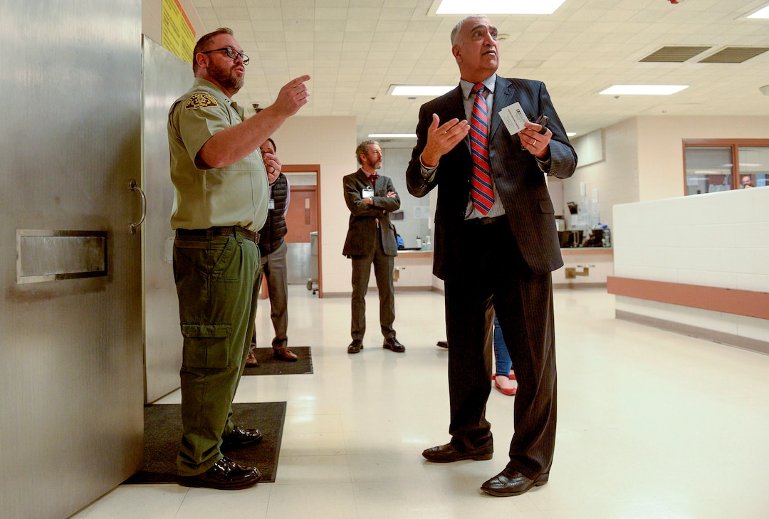 (Leah Hogsten  |  The Salt Lake Tribune) “Criminal justice reform is owning our decisions and figuring out how we can systematically improve,” said Salt Lake County District Attorney Sim Gill, center, entering the Salt Lake County Jail with eight employees led by Salt Lake County Sheriff Department’s Captain Corey Kiddle, left, Dec. 6, 2019. Gill is pushing for the roughly 100 attorneys under his leadership in Salt Lake County and the district attorney’s office to visit the correctional facilities in which individuals prosecuted by their office are placed.