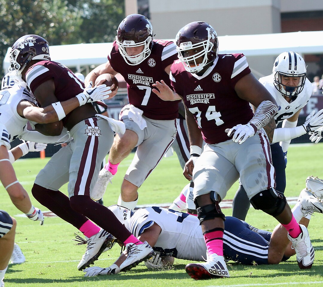 Mississippi State quarterback Nick Fitzgerald (7) leaps over a BYU defender to score a touchdown during the first half of an NCAA college football game in Starkville, Miss., Saturday, Oct. 14, 2017. (AP Photo/Jim Lytle)