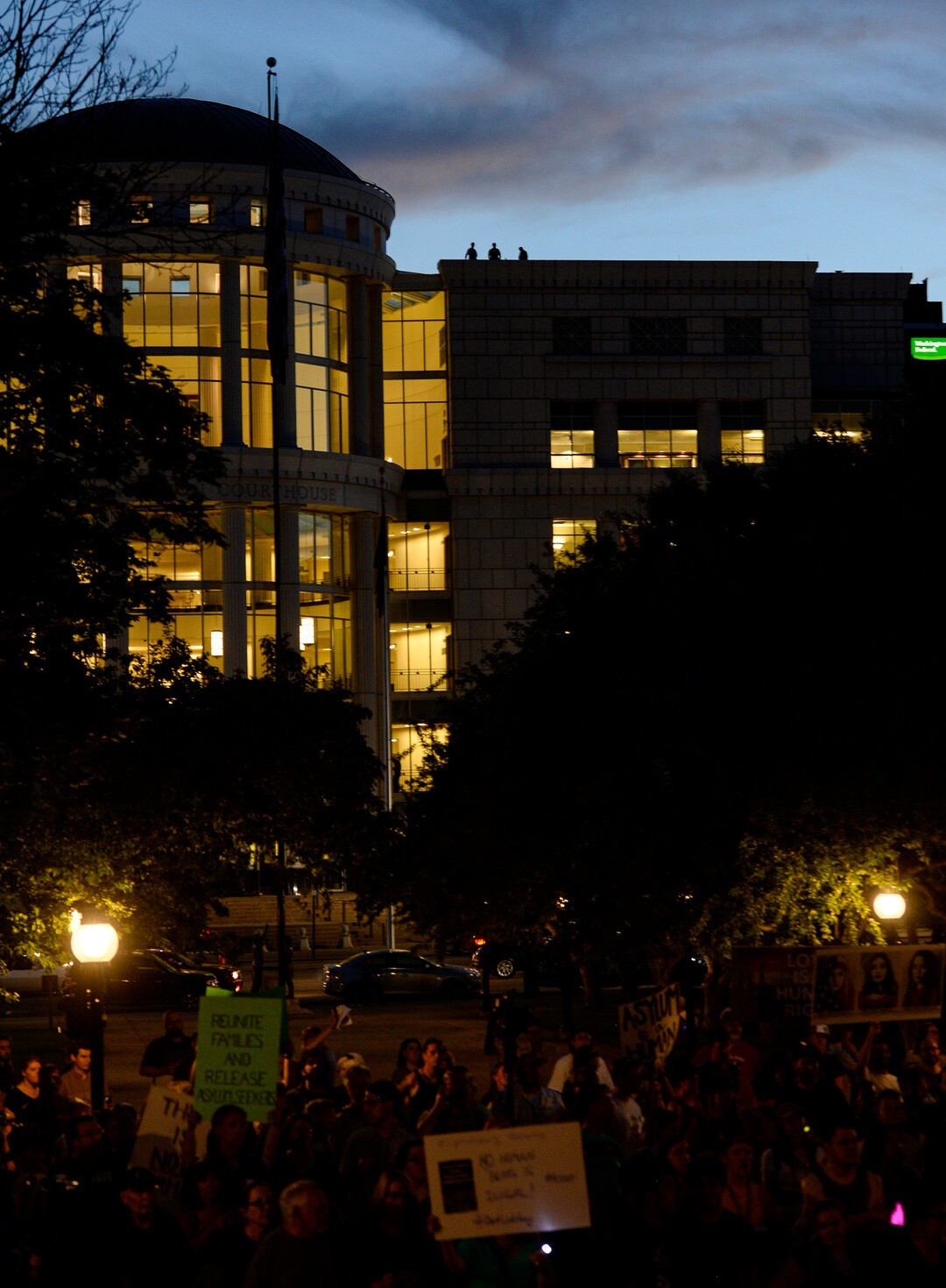 (Leah Hogsten  |  The Salt Lake Tribune) Police watch over the vigil from atop the Scott Matheson Courthouse across State Street during Lights for Liberty: A Vigil to End Human Detention Camps at Washington Square, July 12, 2019 to protest the inhumane conditions faced by refugees.
