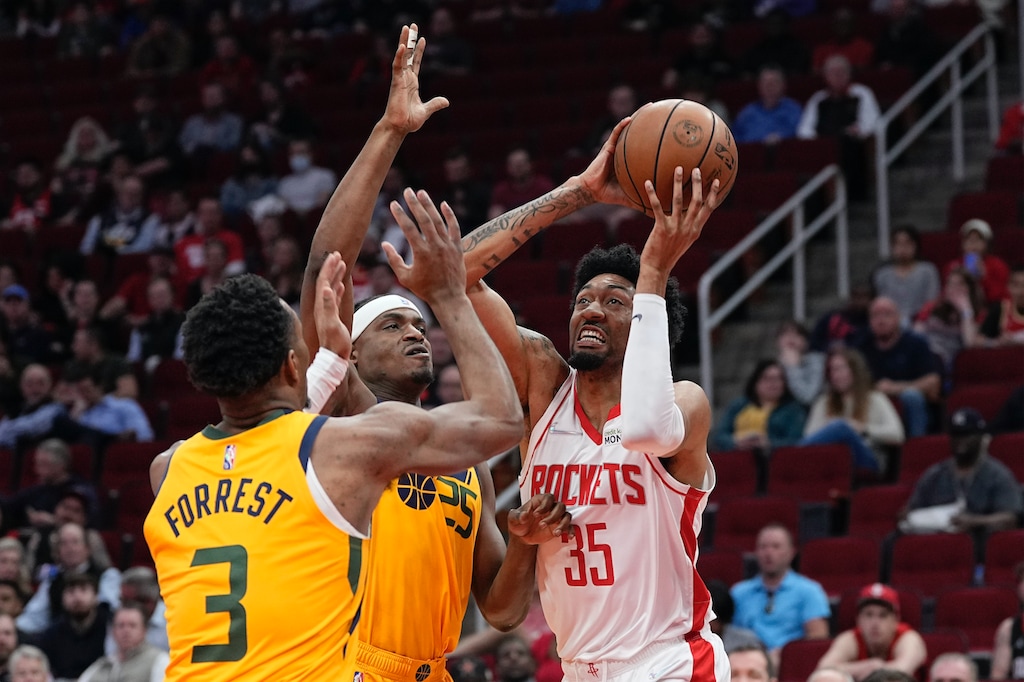 Houston Rockets' Christian Wood (35) shoots as Utah Jazz's Danuel House Jr. (25) and Trent Forrest (3) defend during the first half of an NBA basketball game Wednesday, March 2, 2022, in Houston. (AP Photo/David J. Phillip)