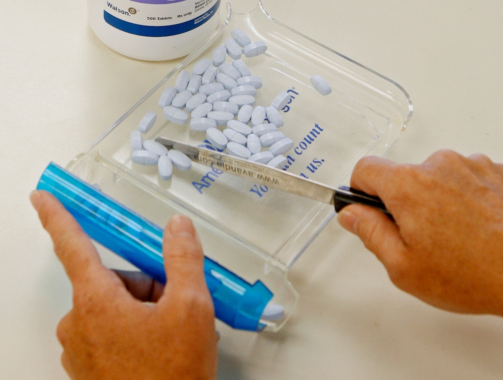 FILE- In this Aug. 5, 2010, file photo, a pharmacy tech poses for a picture with prescription medication at a pharmacy in Edmond, Okla. (AP Photo/Sue Ogrocki, File)
