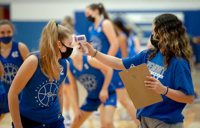 (Francisco Kjolseth  | The Salt Lake Tribune) Assistant coach for the Fremont girls basketball team Abigail Broadbent checks the teams temperature, including Halle Duft, before the start of practice on Wednesday, Feb. 24, 2021.