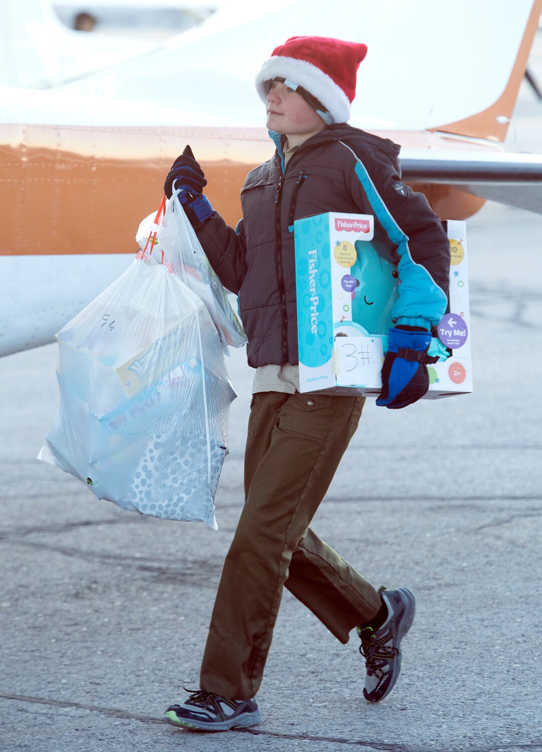 (Rick Egan  |  The Salt Lake Tribune) Boy Scout, Spencer Boyer of Highland, Utah loads up some of the donations for Centennial Elementary School, in Roosevelt, Utah. Boyer helped gather items for the school as part of his eagle scout project. Volunteer pilots from the Utah Wing of Angel Flight West,  brought school supplies and gifts to students in Roosevelt on their annual Santa Flight. Friday, December 8, 2017.
