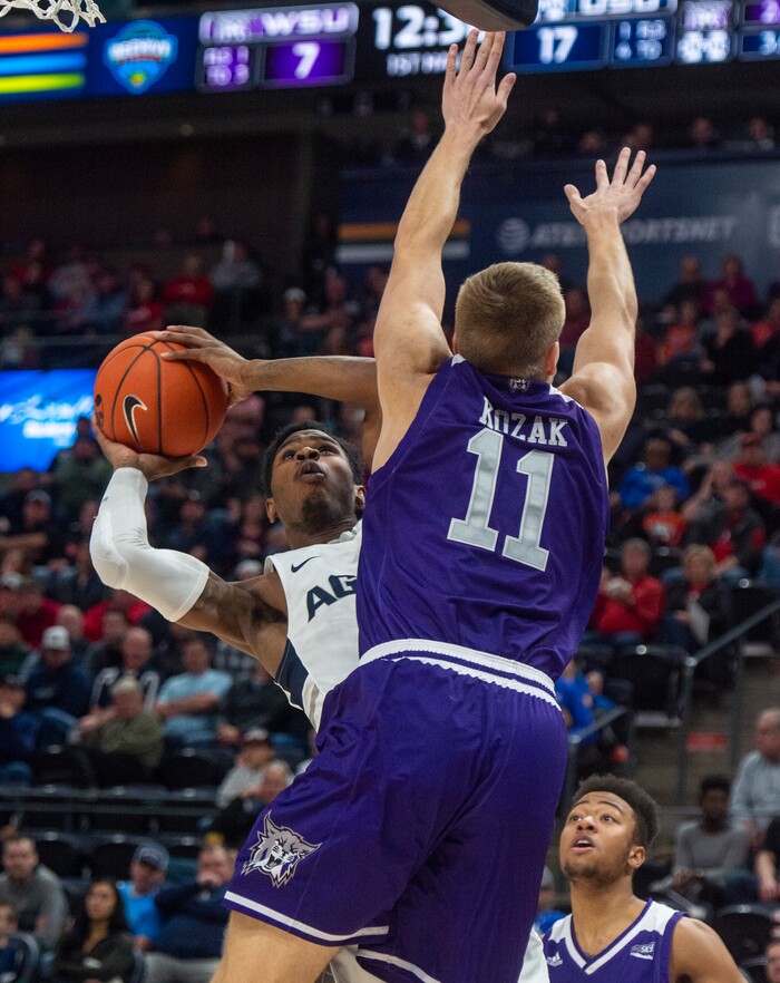 (Rick Egan  |  The Salt Lake Tribune)   Utah State Aggies guard Tauriawn Knight (1) takes a shot, as Weber State Wildcats forward Michal Kozak (11) defends, in the Beehive Classic, between against the Utah State Aggies and Weber State Wildcats, a the Vivint Smart Home Arena, Saturday December 8, 2018.

 