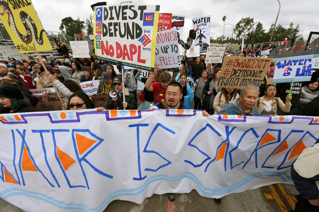 File - In this Jan. 2, 2017, file photo, protesters rally against the Dakota Access Pipeline behind the 128th Rose Parade in Pasadena, Calif. The front lines of the battle against the $3.8 billion Dakota Access pipeline are shifting away from the dwindling encampment in North Dakota. (AP Photo/Michael Owen Baker, File)