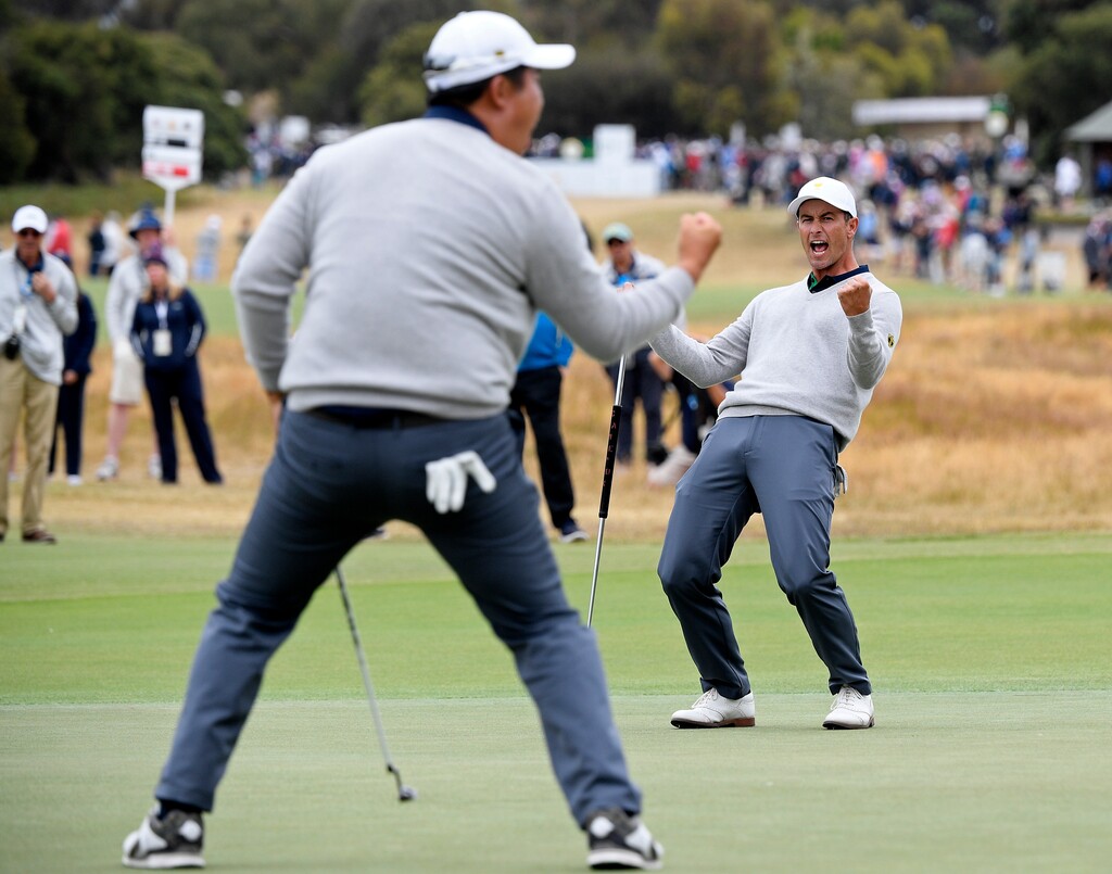 International team player Byeong Hun An of South Korea, left, celebrates a birdie on the 17th green with playing partner Adam Scott of Australia in their fourball match during the President's Cup golf tournament at Royal Melbourne Golf Club in Melbourne, Saturday, Dec. 14, 2019. (AP Photo/Andy Brownbill)