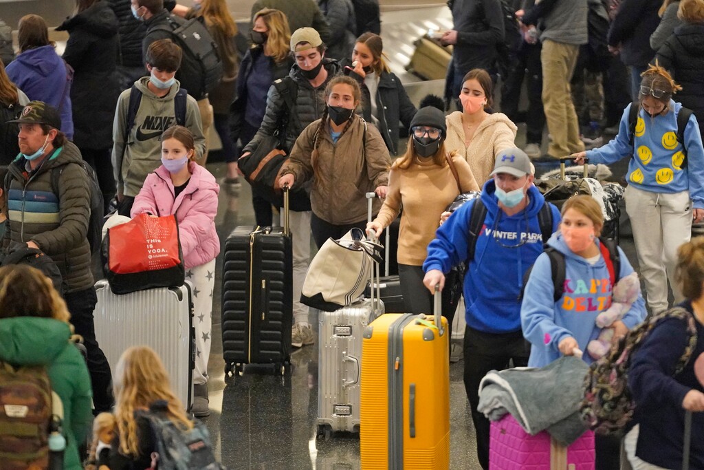 (Rick Bowmer | AP) Travelers pass through Salt Lake City International Airport Monday, Dec. 27, 2021, in Salt Lake City.