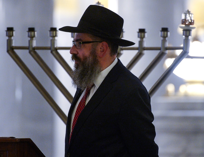Leah Hogsten  |  The Salt Lake Tribune   Rabbi Benny Zippel with Chabad Lubavitch of Utah was emcee of the 12th annual Hanukkah celebration at the Utah Capitol, Dec. 2, 2018. The event was also dedicated as 'A Salute to a Hero', in tribute to the late Maj. Brent Taylor of North Ogden, as the Menorah was kindled by his wife, Jennie Taylor.