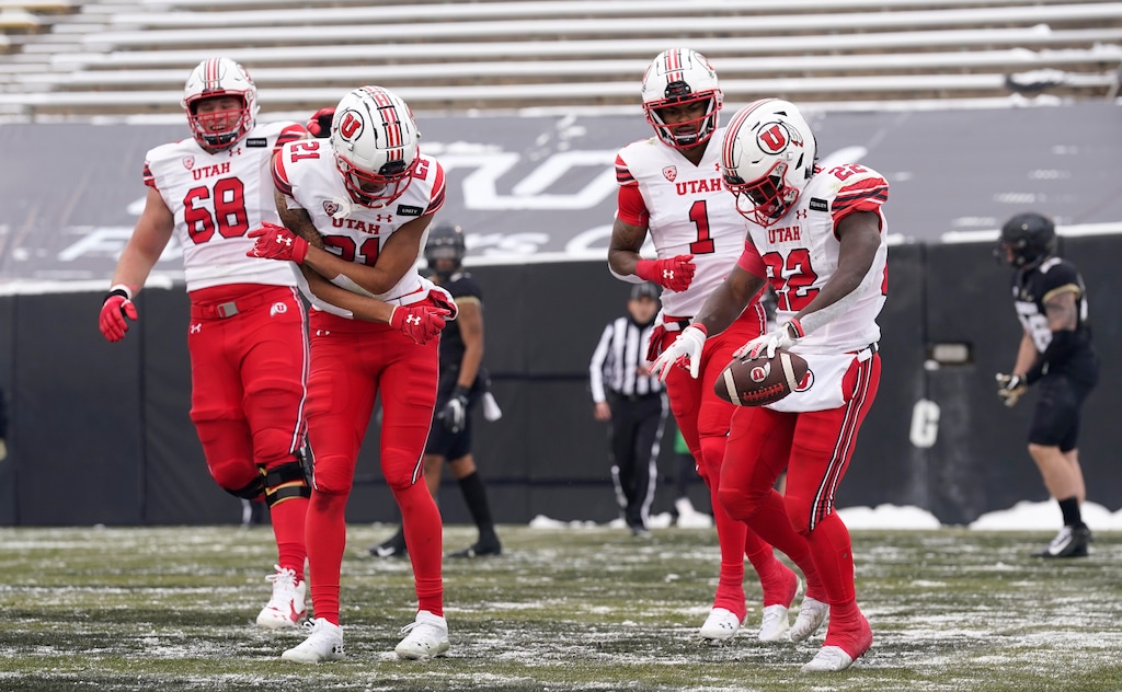 Utah running back Ty Jordan, right, celebrates after his touchdown run with, from left, offensive lineman Jaren Kump and wide receivers Solomon Enis and Bryan Thompson in the second half of an NCAA college football game against Colorado, Saturday, Dec. 12, 2020, in Boulder, Colo. Utah won 38-21. (AP Photo/David Zalubowski)