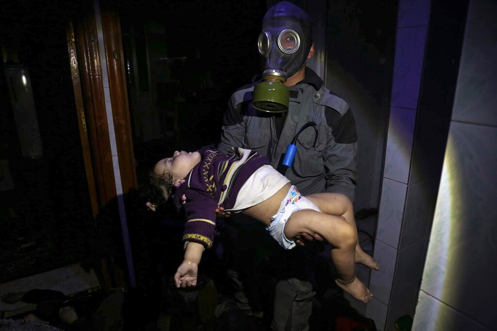 EDS NOTE: GRAPHIC CONTENT - This image, released early Sunday, April 8, 2018, by the Syrian Civil Defense White Helmets, shows a rescue worker carrying a child after a suspected chemical weapons attack in the rebel-held town of Douma, near Damascus, Syria. Syrian rescuers and medics say a poison gas attack on Douma has killed at least 40 people. The Syrian government denied the allegations, which could not be independently verified. The alleged attack in the town of Douma occurred Saturday night amid a resumed offensive by Syrian government forces after the collapse of a truce. (Syrian Civil Defense White Helmets via AP)
