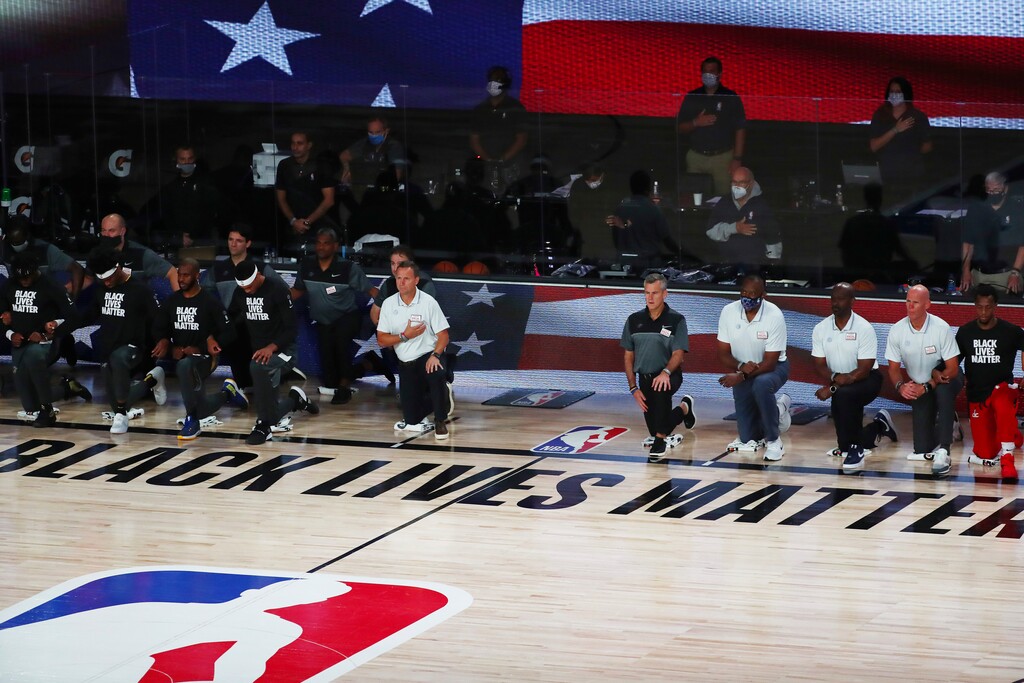 (Kim Klement | Pool photo via AP)  Members of the Oklahoma City Thunder and the Washington Wizards kneel during the National Anthem before a NBA basketball game at AdventHealth Arena Sunday, Aug 9, 2020 in Lake Buena Vista, Fla.
